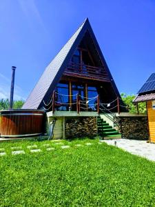 a large house with a gambrel roof with a green lawn at Casuta din LAZ in Onceşti