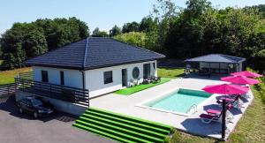 a small house with a swimming pool and two umbrellas at La Casa di Anna in Slatina Varoš