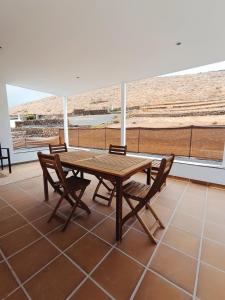 a wooden table and chairs on a patio with a view at Casa Rinaifi in Guatiza