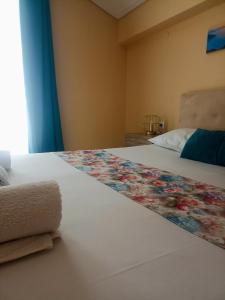 Un dormitorio con una cama con una manta de flores. en John's Apartment 4 in Argostoli, en Argostoli 8 fotos más