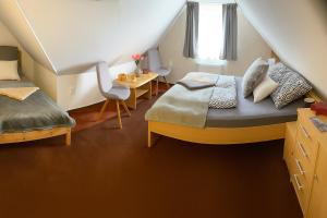 a attic bedroom with two beds and a table at Relax Apartman-Sümeg in Sümeg