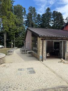 a building with tables and benches in the sand at Malga Filippi 1241 in Polino