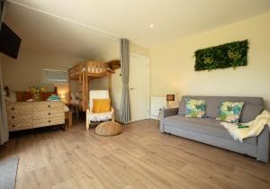 a living room with a couch and a bunk bed at Luxury Silver Birch Lodge: Hot Tub/BBQ/Fire Pit in Toppesfield +64 photos