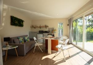 a living room with a couch and a table and chairs at Luxury Silver Birch Lodge: Hot Tub/BBQ/Fire Pit in Toppesfield