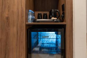 a small oven in a cabinet with bottles of water at Hayah Golden Hotel in Medina