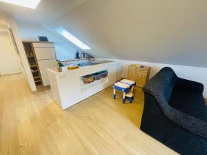 a living room with a couch and a kitchen at Klimatisierte Ferienwohnung in Seenähe in Zülpich