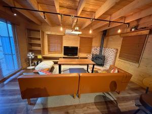 a living room with a couch and a table at 裏に川がある貸切別荘 in Takashima