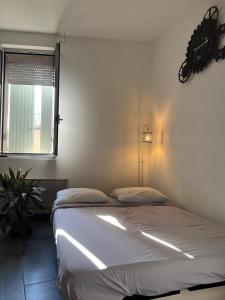 Un dormitorio con una cama y una ventana y una lámpara. en Cosy Studio hyper centre avec kitchenette & Climatisation, en Carpentras