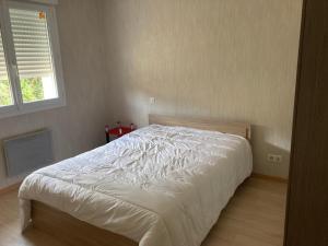 a white bed in a bedroom with a window at Maison de vacances in Cosnac