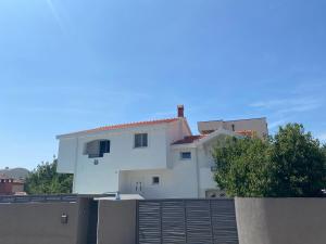 una casa blanca situada encima de una valla en Villa Balera, en Zadar