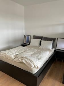 a large bed with white sheets and pillows on it at Schöne Wohnung in Bahnhofsnähe in Wels