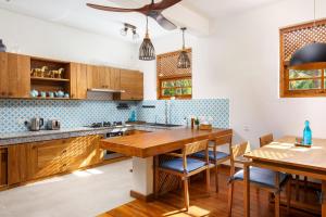 a kitchen with wooden cabinets and a wooden table at Kandakuliya Sunrise Beach Villas in Kalladi