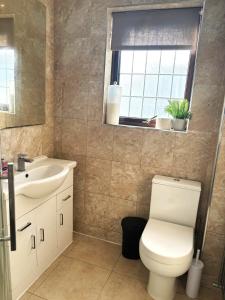 ホーンチャーチにあるLuxury 4 Bedroom House with Free Parkingのトイレ、洗面台、鏡のあるバスルーム +13枚の写真