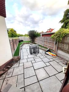 ホーンチャーチにあるLuxury 4 Bedroom House with Free Parkingのパティオ(テーブル、ベンチ付)