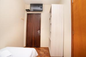 a room with a bed and a wooden door at Casa Santa Cruz in Passo Fundo