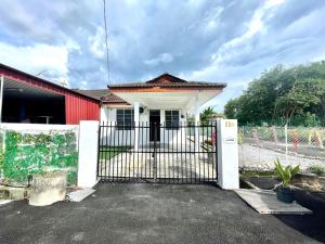 a house with a gate and a red building at 11Acozy#6pax#singlestoreyhouseAlmaBukitMertajam in Bukit Mertajam