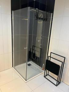 una doccia in vetro in un bagno con una sedia di Apartament Perła w Kłodzku a Kłodzko Altre 8 foto