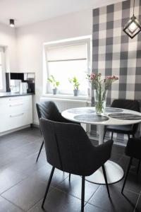 a dining room with a table and chairs and a kitchen at Apartament Perła w Kłodzku in Kłodzko +8 photos