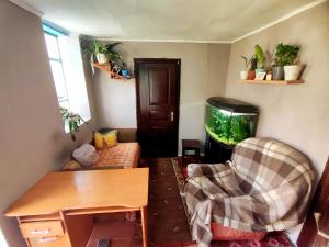 a living room with a fish tank and a chair at Burshtyn in Svityazʼ
