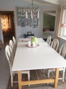 a dining room table with a white table and chairs at Pollyville in Lillesand