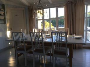 a dining room with a table and chairs and a chandelier at Pollyville in Lillesand