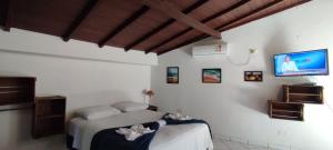 a bedroom with a bed and a tv on the wall at Maré Leve Maresias in Maresias