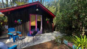 una piccola casa con due sedie e un tavolo di Le Cabanon entouré de Pins a Lacanau