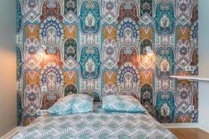 a bed in front of a wall with a wallpaper at Appartement duplex centre historique d'Auray in Auray
