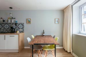 a dining room with a wooden table and yellow chairs at Appartement duplex centre historique d'Auray in Auray