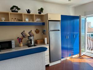 a kitchen with blue cabinets and a refrigerator at Apartment Simo in Herceg-Novi