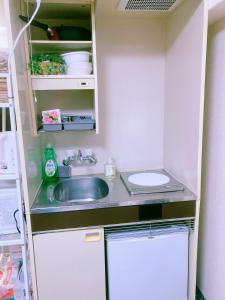uma pequena cozinha com um lavatório e um WC em Shinjuku House-1 em Tóquio