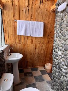 a bathroom with a toilet and a towel hanging on a wooden wall at Kaasham Cabins Olpejeta in Nanyuki +12 photos