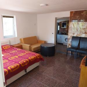 a bedroom with a bed and a couch and a kitchen at Studio Relax in Travnik