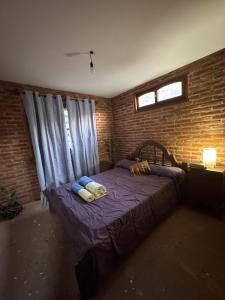 a bedroom with a bed in a brick wall at Hostel Vida 