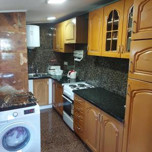 a kitchen with wooden cabinets and a washer and dryer at Studio Relax in Travnik