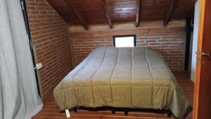 a bed in a room with a brick wall at Hostel Vida  +6 photos