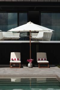 two chairs and an umbrella next to a pool at Hebanowe in Załuczne +25 photos