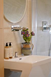 a bathroom sink with a vase with flowers on it at Hebanowe in Załuczne
