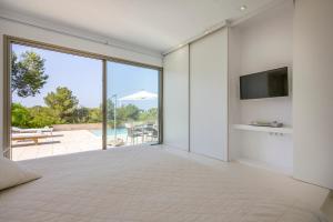 a bedroom with a large bed and a tv on a wall at Rent Your Luxury 2 Bedroom Villa, Ibiza Villa 1025 in Talamanca +18 photos