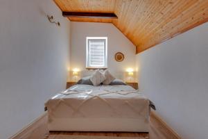 a bedroom with a bed with a wooden ceiling at Charly's Apartment in Smoljanac