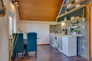 a kitchen with a table and some blue chairs at Charly's Apartment in Smoljanac