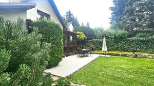 a garden with a table and a closed umbrella at Rekreační objekt Petra in Kračín +7 photos