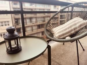 a table and chair with a lamp on a balcony at Studio Fifty9 in Knokke-Heist +2 photos