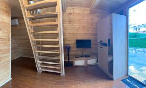 a wooden staircase in a room with a television at Cottage by the sea in Kobuleti
