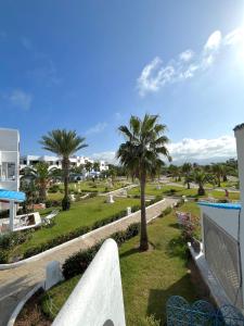 a view of a park with palm trees and buildings at Private beach 100 meters, relaxing stay guaranteed in Fnidek
