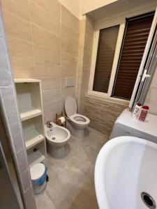 a bathroom with a toilet and a bidet and a sink at CasaDiFlavio in Torvaianica