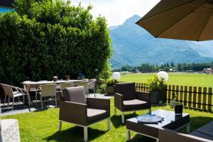 a patio with tables and chairs and an umbrella at Chalet Austria, famous ski areas around us, 15 min to salzburg city, direct mountain view, up to 10 people in Golling an der Salzach