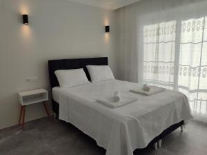 a bedroom with a bed with two towels on it at Villa Beyaz İnci Dalaman-Villa White Pearl Dalaman in Dalaman