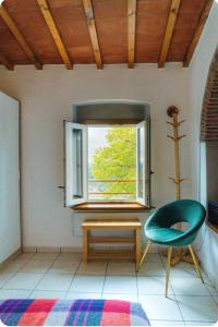 アルティミーノにあるBilocale Artimino campagna toscanaの窓、椅子、テーブルが備わる客室です。
