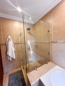a bathroom with a shower and a sink at Tsheryl's Guesthouse in Centurion